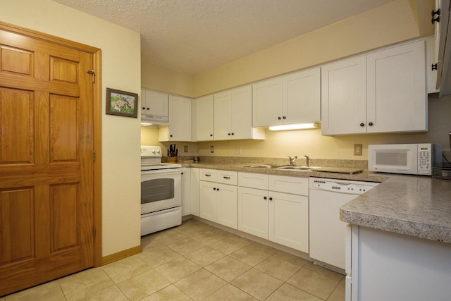 kitchen with a sink, under cabinet range hood, a textured ceiling, white appliances, and white cabinets