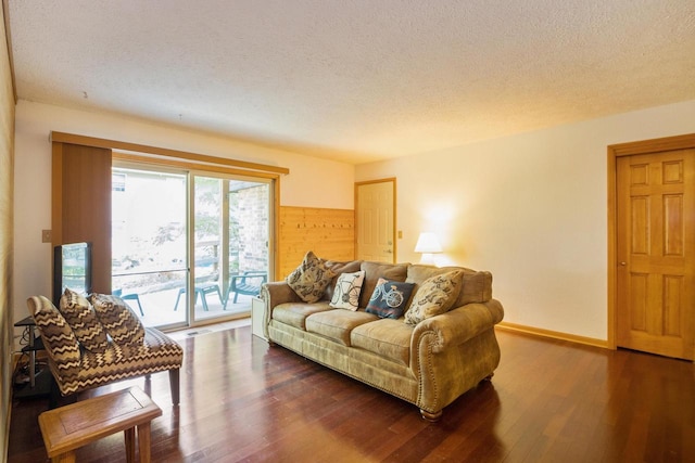 living room with baseboards, a textured ceiling, and wood finished floors