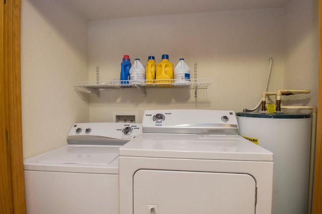 washroom with water heater, laundry area, and washer and clothes dryer