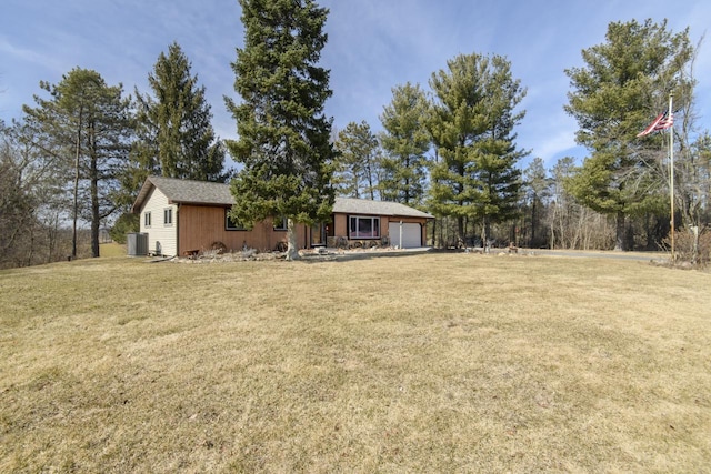 view of yard featuring central AC and an attached garage