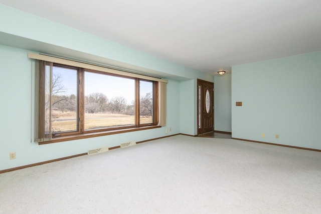 unfurnished room featuring visible vents, carpet floors, and baseboards