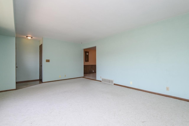 empty room featuring visible vents, carpet flooring, and baseboards