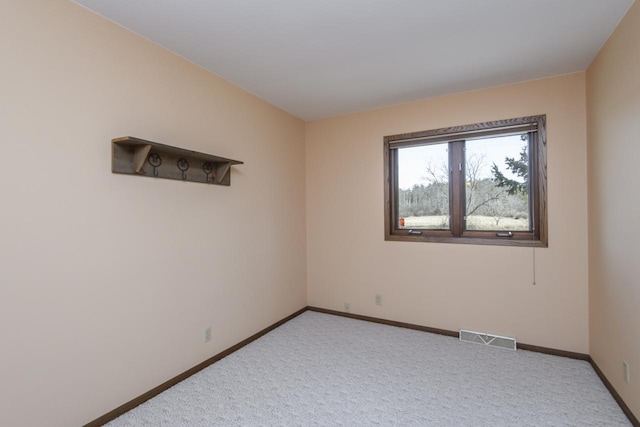 unfurnished room featuring visible vents, carpet flooring, and baseboards