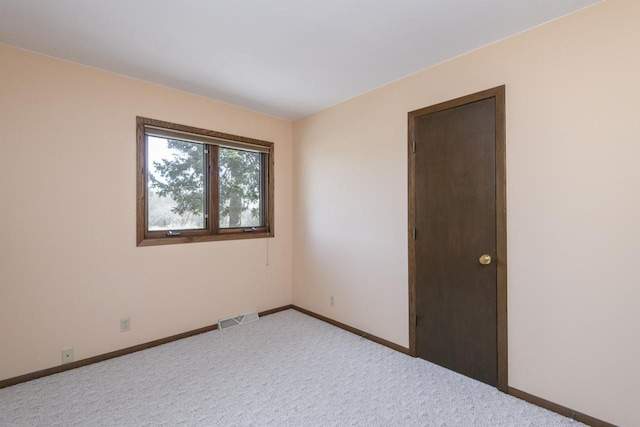 carpeted empty room with baseboards and visible vents