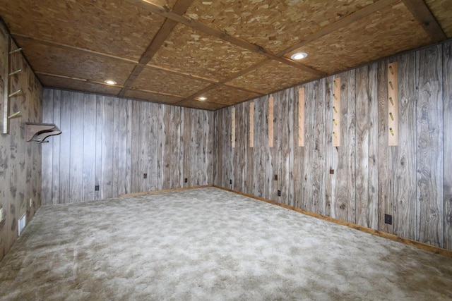 unfurnished room with carpet and wood walls