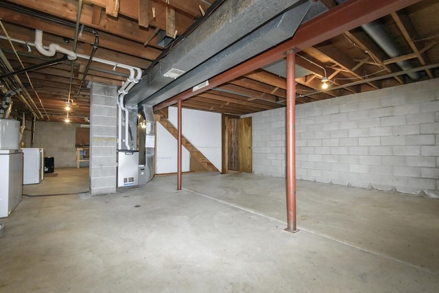 unfinished below grade area with stairs, washer / clothes dryer, and heating unit