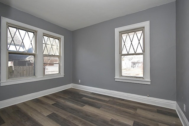 empty room featuring baseboards and dark wood-style flooring