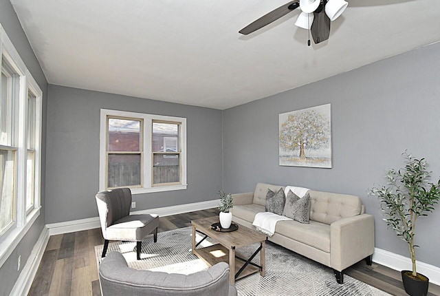 living room with baseboards, a ceiling fan, and wood finished floors