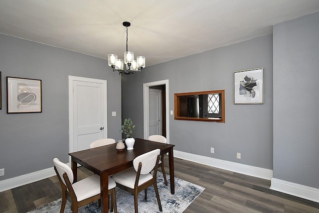 dining area featuring an inviting chandelier, baseboards, and dark wood-style flooring