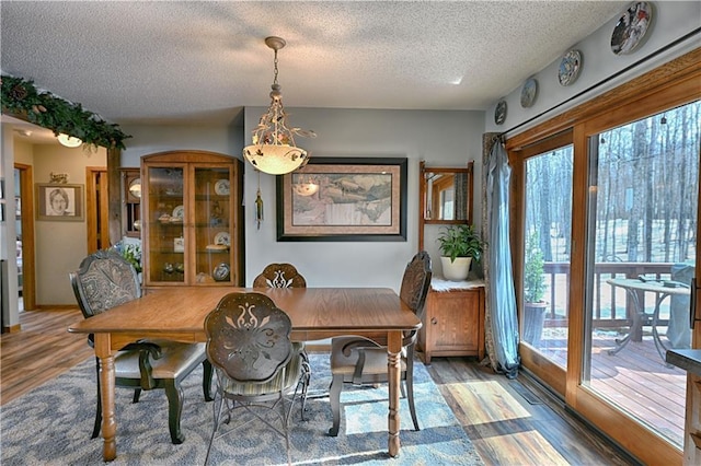 dining space with wood finished floors and a textured ceiling