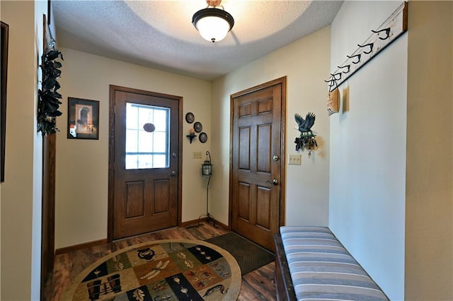 entrance foyer with baseboards, a textured ceiling, and wood finished floors