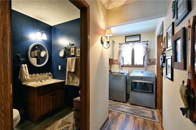 interior space featuring washer and clothes dryer, a sink, laundry area, and wood finished floors