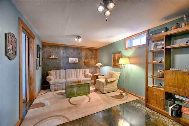 living room featuring baseboards, a textured ceiling, and wood walls