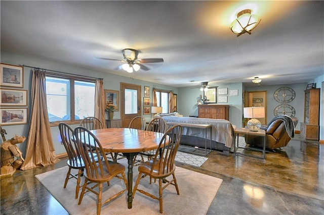 dining room with plenty of natural light, baseboards, concrete floors, and ceiling fan