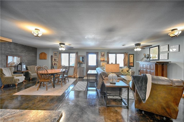 living room featuring a ceiling fan, a wealth of natural light, and finished concrete floors