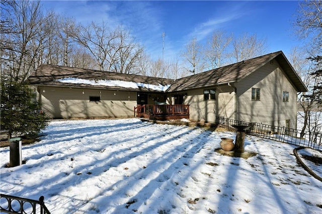 snow covered house featuring a deck