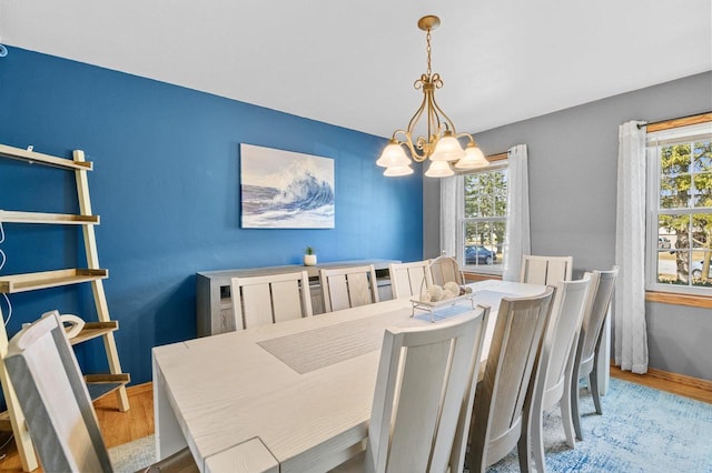 dining area featuring a chandelier, a healthy amount of sunlight, and wood finished floors