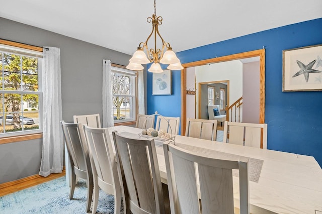 dining room with baseboards, wood finished floors, and a chandelier