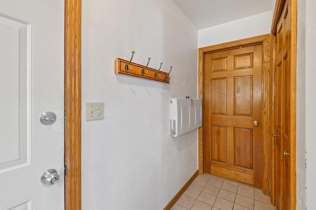 doorway to outside featuring light tile patterned floors and baseboards