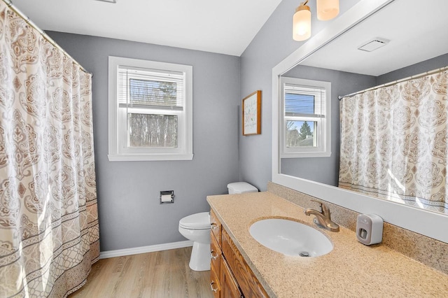 full bathroom with baseboards, toilet, a healthy amount of sunlight, and wood finished floors