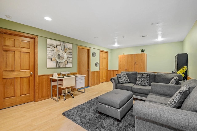 living area featuring wainscoting, light wood-style flooring, and wood walls