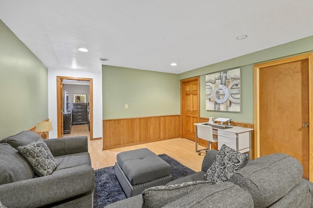 living room with recessed lighting, wood finished floors, wood walls, and wainscoting