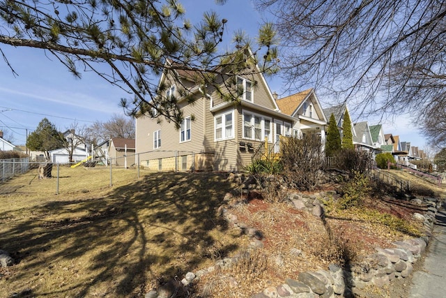 view of property exterior featuring a lawn and fence