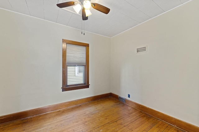 unfurnished room with a ceiling fan, hardwood / wood-style flooring, baseboards, and visible vents