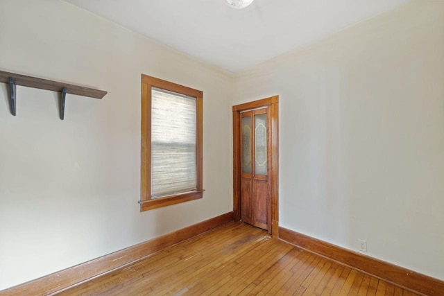 empty room featuring baseboards and light wood finished floors