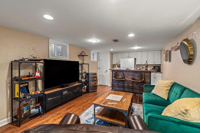 living room with visible vents, recessed lighting, baseboards, and wood finished floors