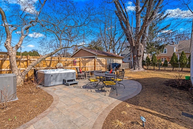 view of patio / terrace with central air condition unit, a fenced backyard, and a hot tub