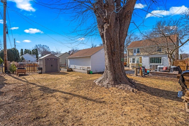 view of yard featuring an outbuilding, fence, a shed, and a patio