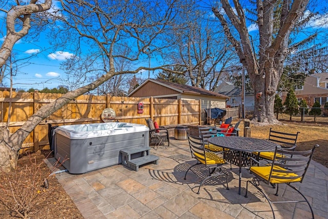 view of patio featuring a fenced backyard, outdoor dining space, and a hot tub