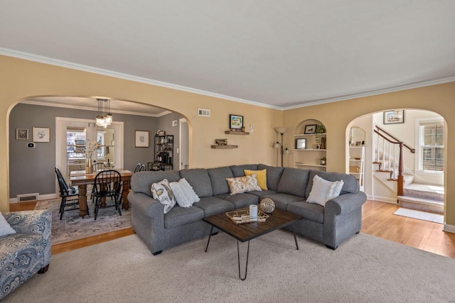 living room with arched walkways, visible vents, and a wealth of natural light