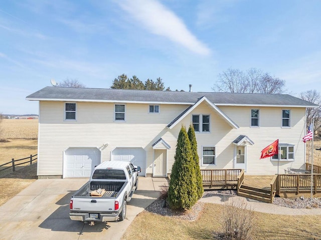 townhome / multi-family property with concrete driveway, fence, a garage, and a wooden deck