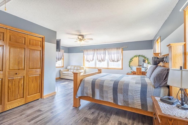 bedroom with baseboards, a textured ceiling, wood finished floors, and a ceiling fan