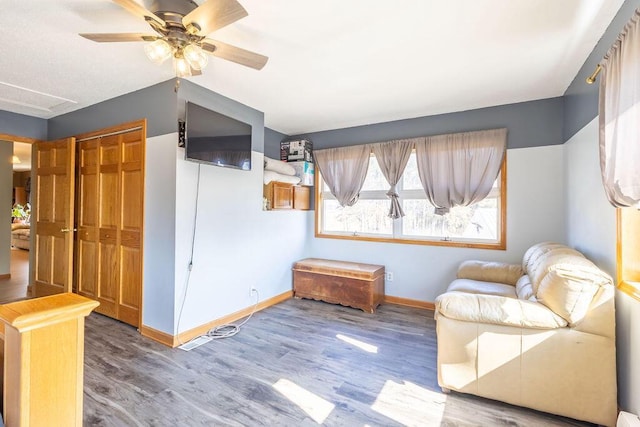 unfurnished room with a ceiling fan, wood finished floors, and baseboards