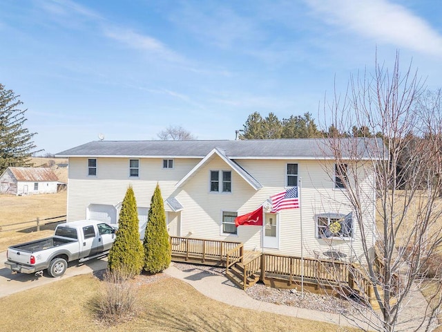 view of front facade featuring a deck, an attached garage, and driveway