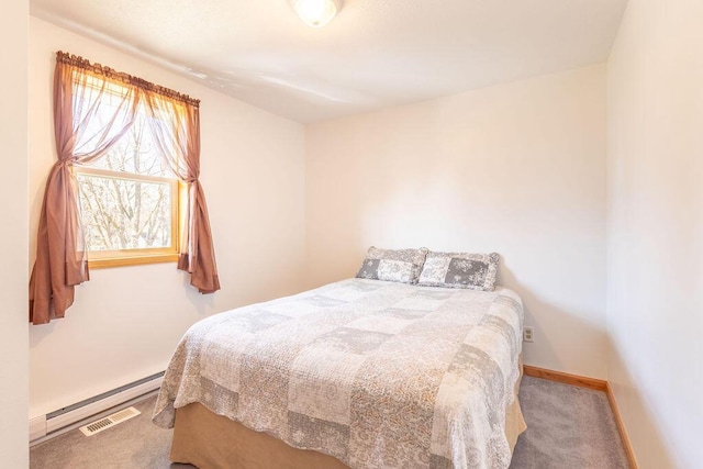 carpeted bedroom with a baseboard heating unit and baseboards