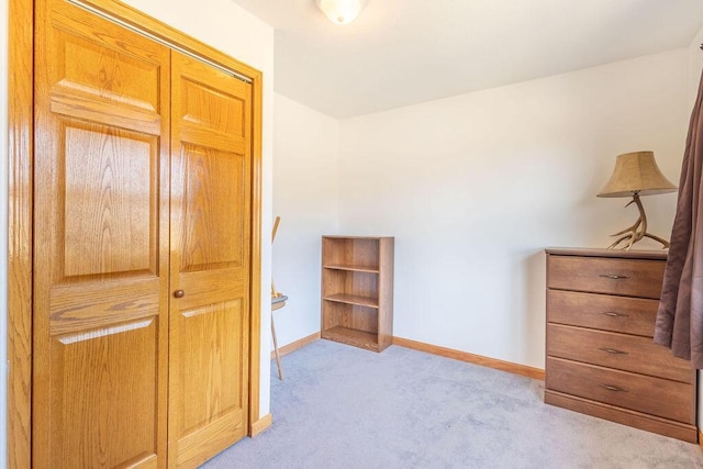 bedroom with baseboards and light carpet