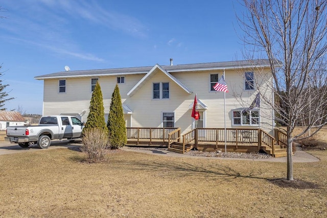 rear view of property with a yard and a wooden deck