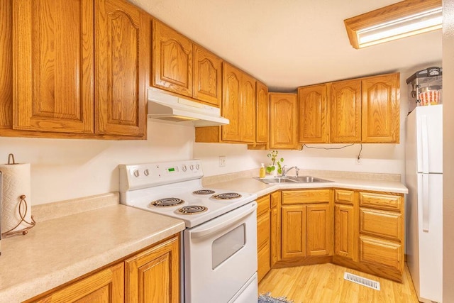 kitchen with visible vents, under cabinet range hood, a sink, white appliances, and light countertops