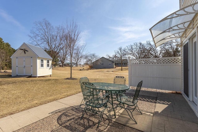 view of patio featuring an outbuilding, a shed, and outdoor dining space