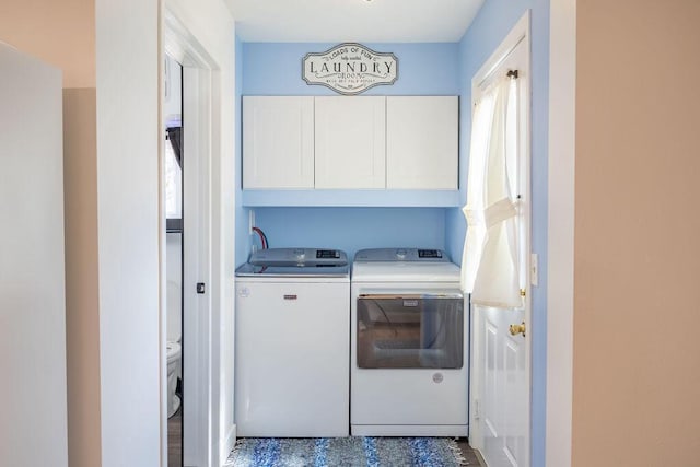 clothes washing area featuring cabinet space and washing machine and dryer