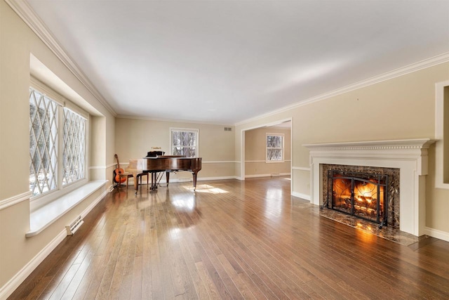 living room featuring a high end fireplace, crown molding, baseboards, and wood-type flooring