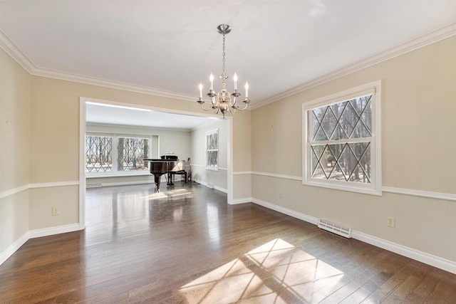 spare room with baseboards, visible vents, wood-type flooring, and a chandelier