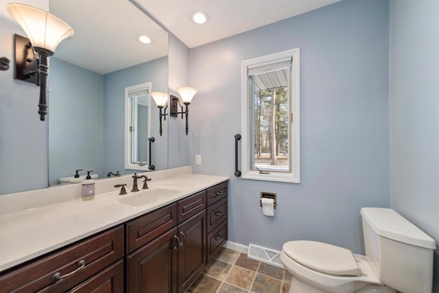 bathroom featuring visible vents, baseboards, toilet, recessed lighting, and vanity