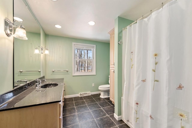 bathroom featuring visible vents, baseboards, toilet, tile patterned floors, and vanity