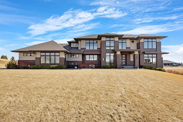 view of front facade featuring a front yard and brick siding