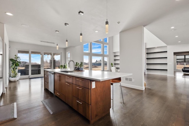 kitchen with dark wood finished floors, open floor plan, a center island with sink, dishwasher, and modern cabinets